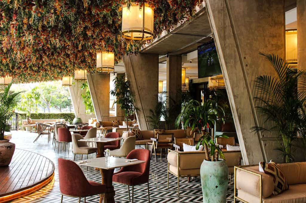 Interior view of Menlyn's new Epicurean Landmark with modern decor, lush plants, and ambient lighting.