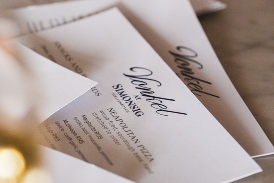 Close-up of event invitation cards for VONKEL at Simonsig, showcasing elegant typography and branding for a wine-tasting event in South Africa.